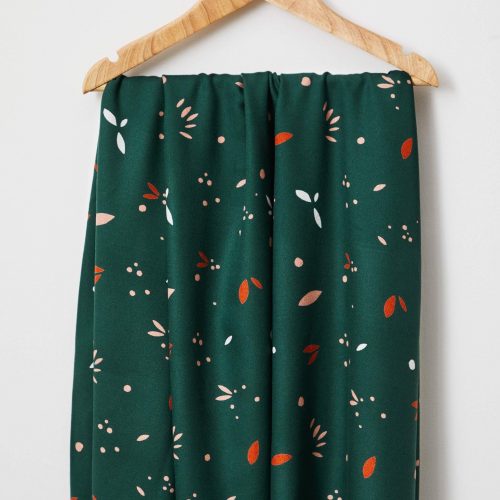 Petal print fabric in green with orange specs