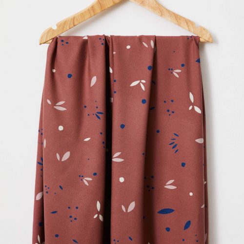 rosewood petal print fabric hanging on a hanger