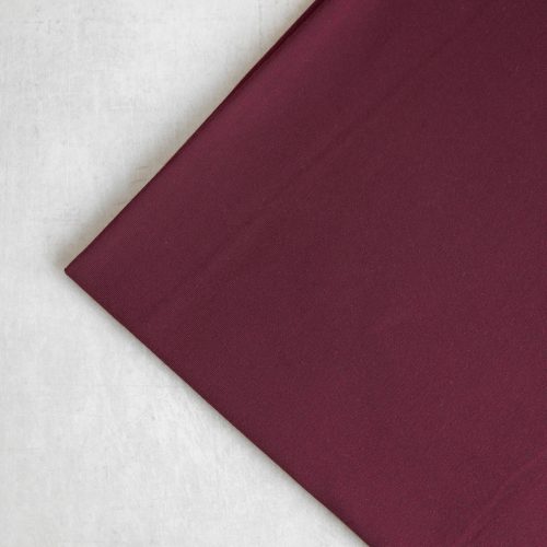 Tencel jersey fabric in burgundy folded neatly into a square