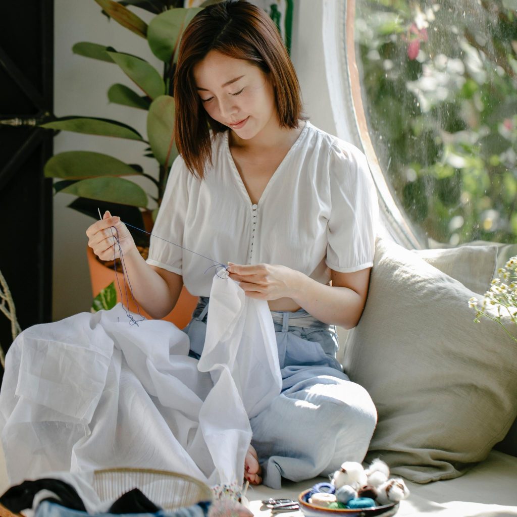 a girl sitting down and sewing