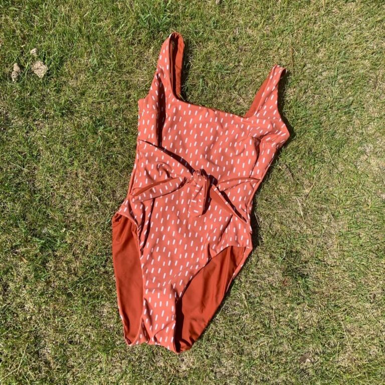 frankie swimsuit sewing pattern for a one piece placed on a grass