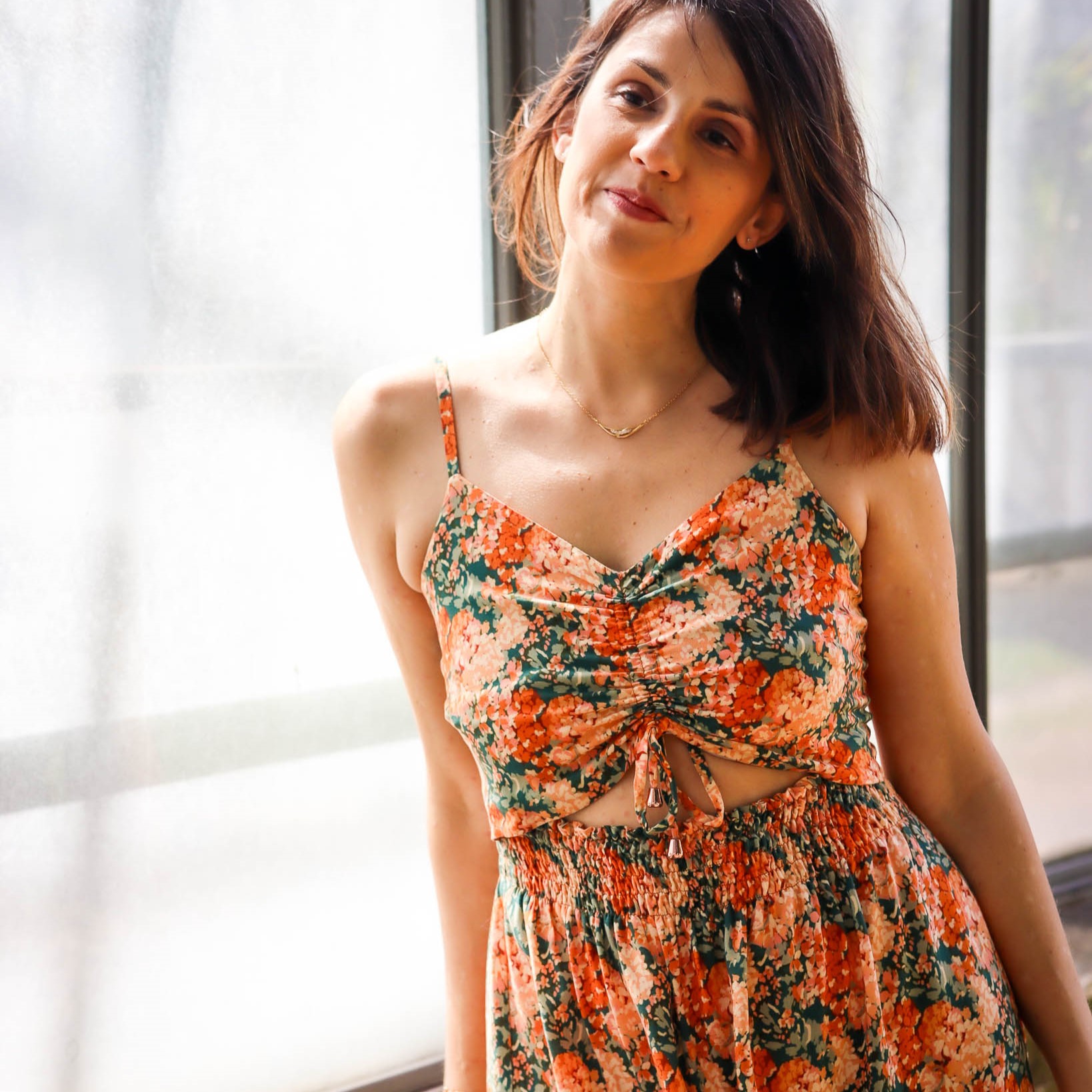 model wearing floral dress with gathering