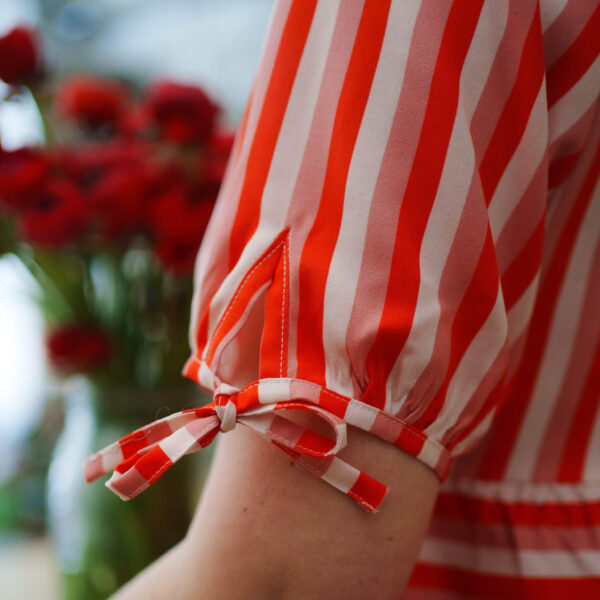 red and pink stripey blouse, the image is a close up of s sleeve