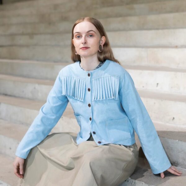 model wearing denim fringed jacket
