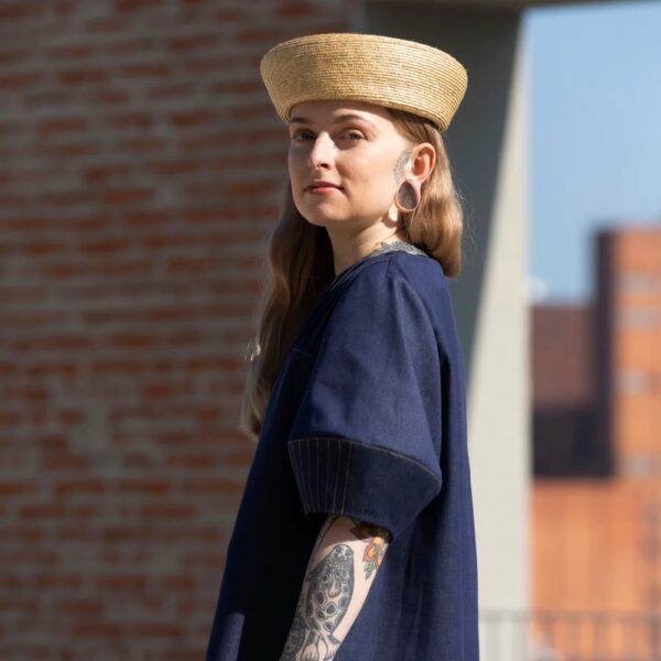 model wearing dark blue indigo denim dress and a straw hat